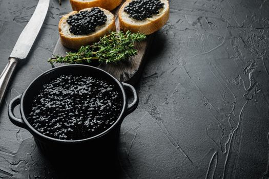Canapes with black sturgeon caviar, on black background with copy space for text