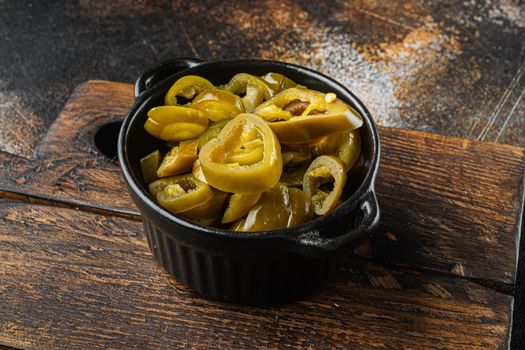 Pickled or canned Jalapeno peppers, on old dark rustic background