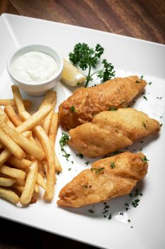 british traditional fish and chips meal on wood table
