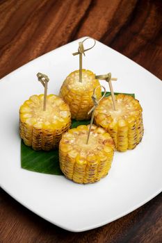 organic sweet corn on the cob vegan tapas snack food on wood table background
