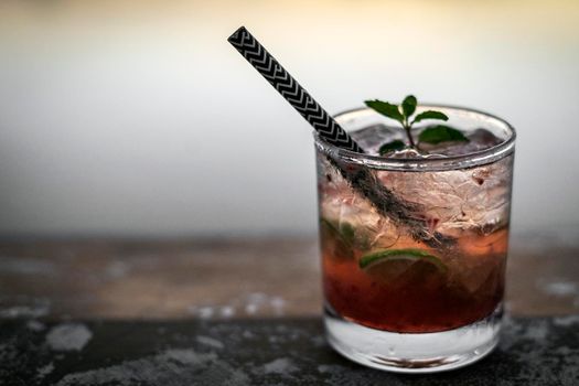 strawberry caipirinha mixed cocktail drink in outdoor bar at sunset