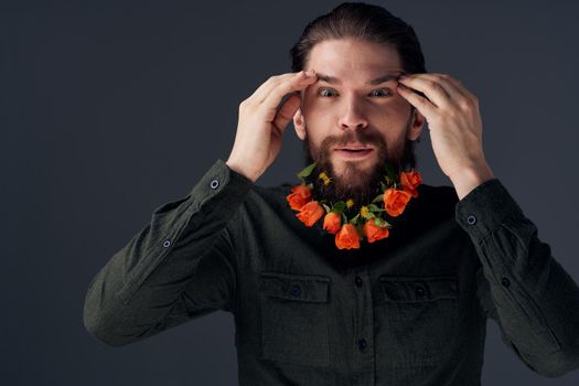 Bearded cheerful man flowers different romance decoration black background. High quality photo
