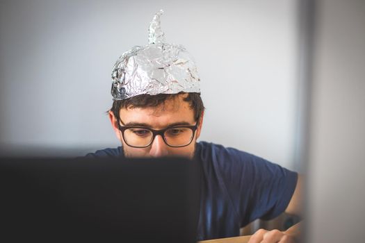 Conspiracy theory concept: young man is wearing aluminum head