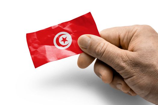 Hand holding a card with a national flag the Tunisia