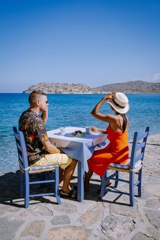 couple men and woman on the beach of Plaka Crete looking out over the blue ocean of Crete Greece