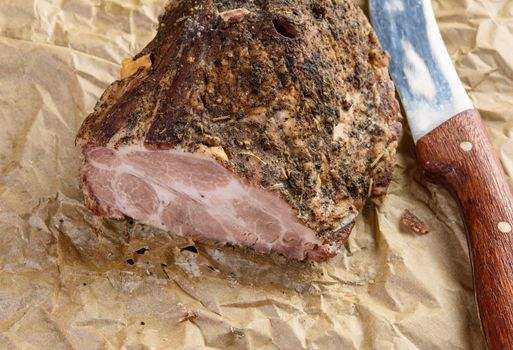 a baked piece of spiced pork neck on brown parchment paper