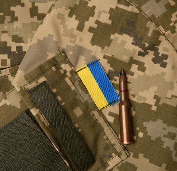 fragment of the sleeve of the uniform of the Ukrainian soldier with the flag of ukraine and patron