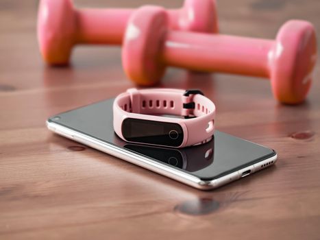 Fitness tracker on smartphone wooden tabletop