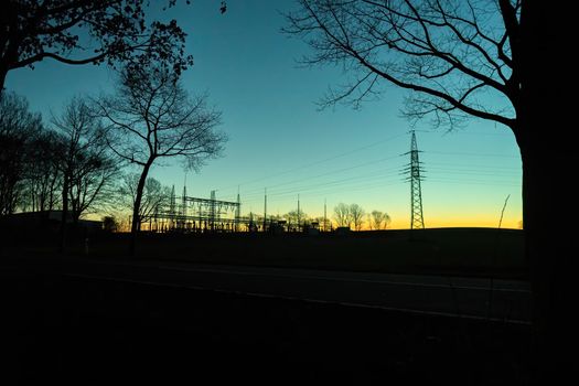 Silhouette of an early morning substation at sunrise in yellow blue light