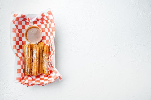 Churros with sugar powder in the box in paper tray, on white background, top view flat lay with space for text, copyspace