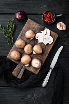 Brown champignons mushroom, on black wooden table background, top view flat lay