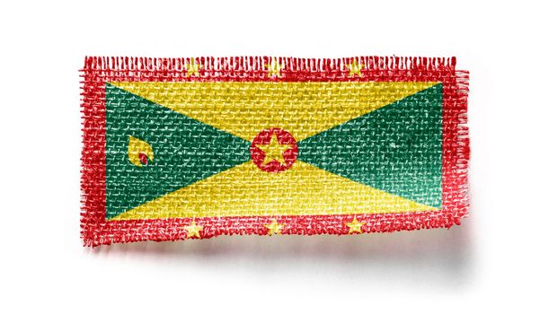Grenada flag on a piece of cloth on a white background
