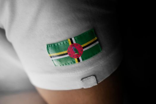 Patch of the national flag of the Dominica on a white t-shirt