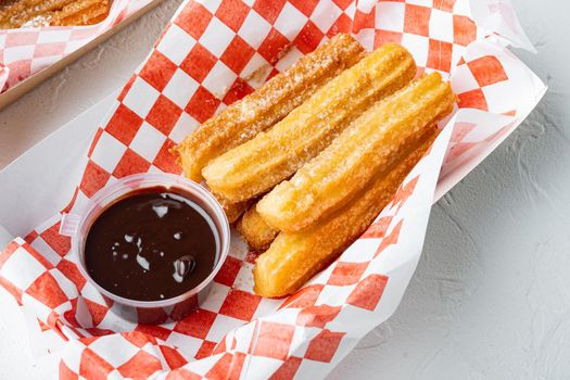 Churros with sugar powder in the box in paper tray, on white background