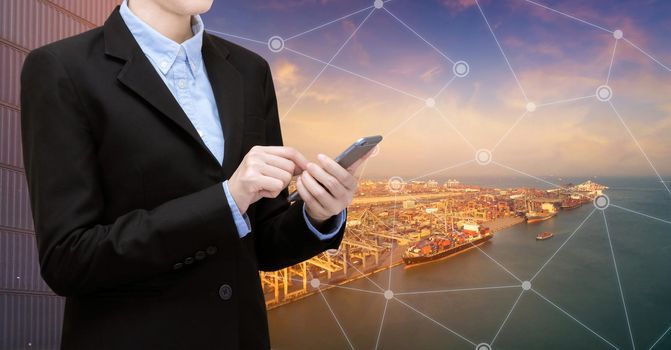 Smart Business woman use smartphone and internet of things technology for Global business connection with global customer for worldwide transportation business.