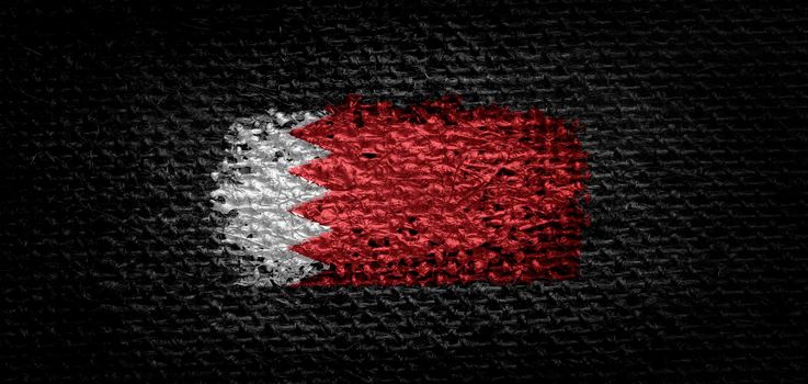 Small national flags of the Bahrain on a light blurry background