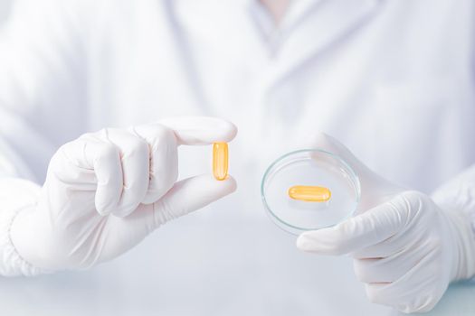 Close up Scientist holding capsule gel in labcoat 