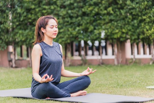 young woman doing yoga outdoors in meditate lotus pose