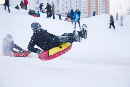 Belarus, the city of Gomel, January 07, 2018.Central Park.Child sledding cheesecake.Sledding off a snow slide.A boy on a sled tubing jumping from a springboard. Dangerous sledging