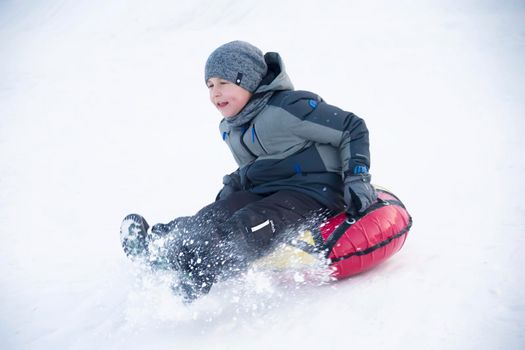 Belarus, the city of Gomel, January 07, 2018.Central Park.Child sledding cheesecake.Sledding off a snow slide.