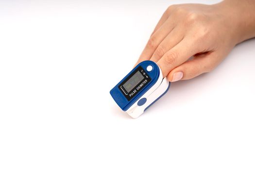 Fingertip Pulse Oximeter on finger. On white background. Device for self health diagnostic