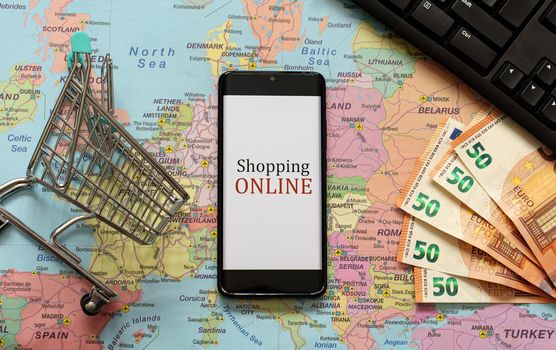 Mobile phone, shopping cart and money. Online shopping concept.