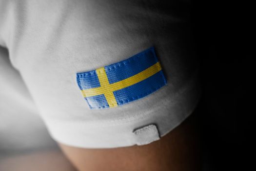 Patch of the national flag of the Sweden on a white t-shirt
