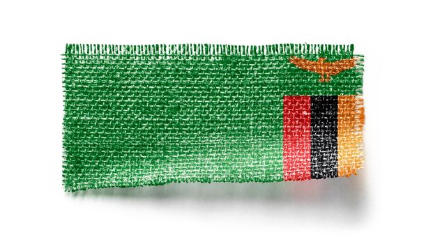 Zambia flag on a piece of cloth on a white background