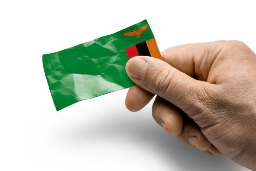 Hand holding a card with a national flag the Zambia