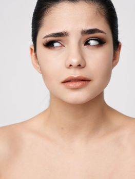 woman with bare shoulders face makeup side glance close-up