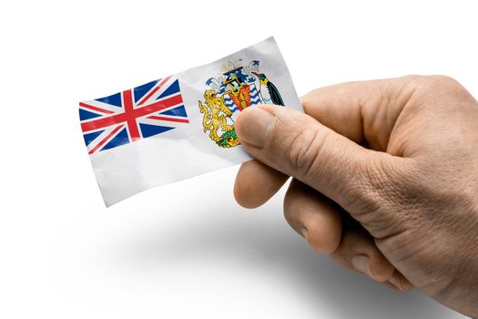 Hand holding a card with a national flag the British Antarctic Territory