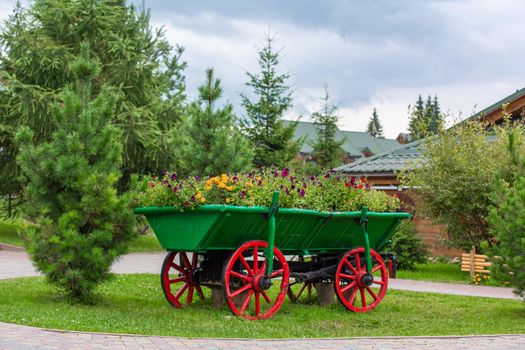 Old style cart with green bush for outdoor backyard decoration