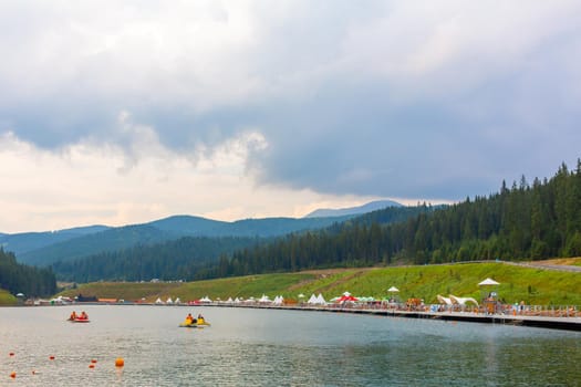Entertaiment of Voda club on the pond among Carpathian mountains. Rental boats for lake tour