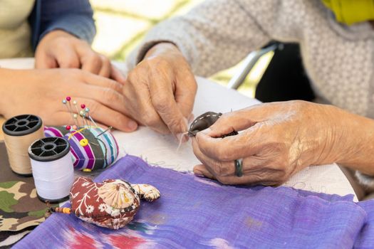 Elderly woman and daughter in the needle crafts occupational therapy for Alzheimer’s or dementia 
