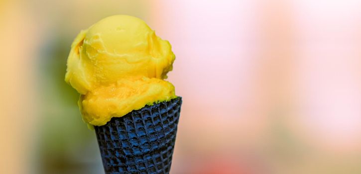 yellow ice cream in a wafer chocolate cone