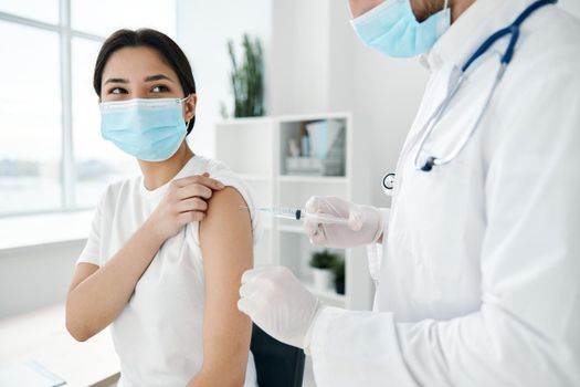 female patient medical masks in hospital and shoulder injection epidemic vaccine