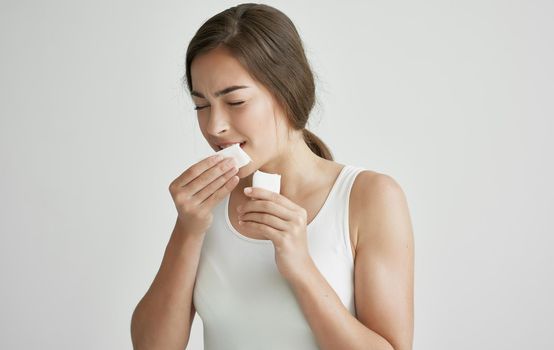 woman wiping her face with a handkerchief feeling unwell health cold