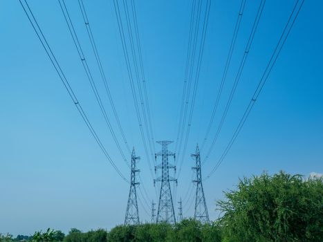 high voltage transmission towers with power line over blue sky background