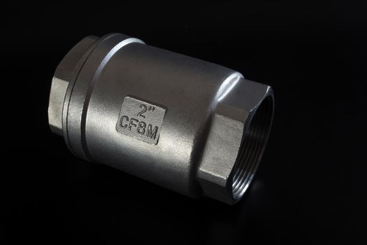 Stainless steel check valve on black background