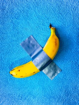 Yellow banana lie taped on blue towel