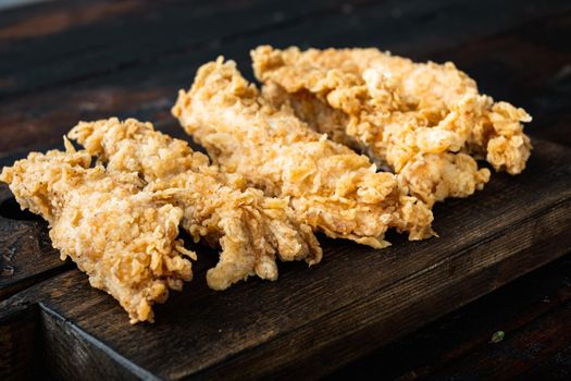 Deep fried crunchy spicy chicken on dark wooden background