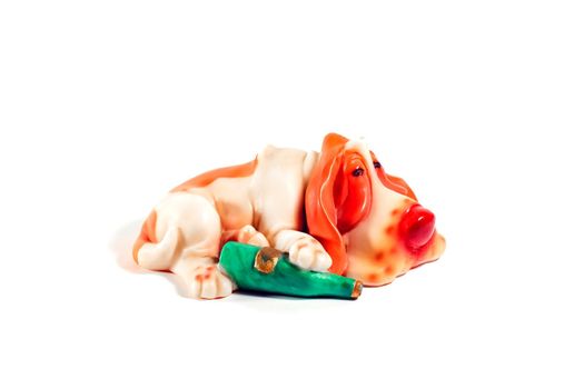 statuette of a sleeping dog with a bottle on a white background