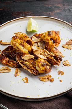 Grilled shrimps or prawns served with Mango chutney crispy garlic, on plate, on old dark wooden table background