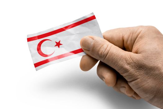 Hand holding a card with a national flag the Northern Cyprus