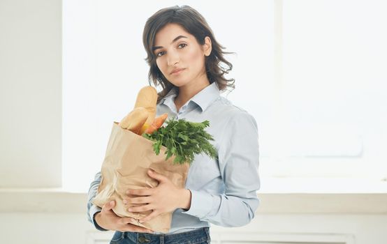 brunette with a package of groceries vegetables greens supermarket shopping