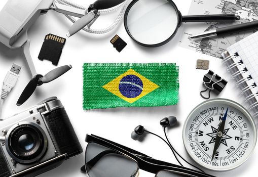 Flag of Brazil and travel accessories on a white background.