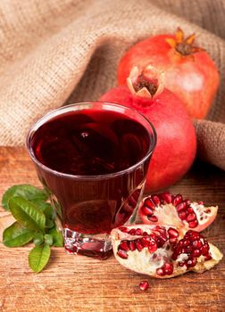 Fresh juicy pomegranate with leaves on a wooden board