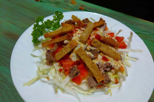 Light salad with fresh cabbage, chicken and parsley pieces.