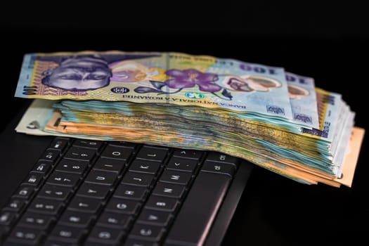 Lei banknotes on keyboard. Selective focus on stack of LEI romanian money. 