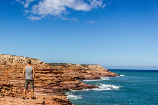 young man enyoing view of the Pot Alley in Kalbarri National Park, with beautiful clouds Western Australia